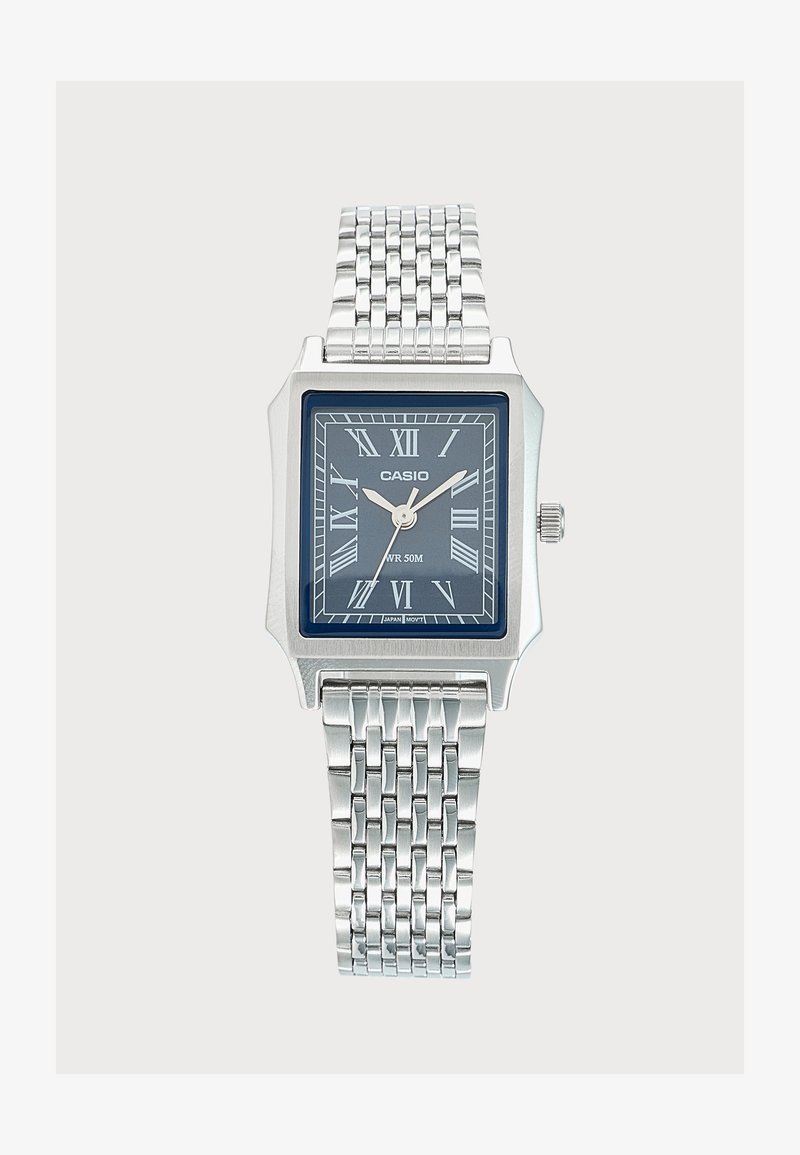 Ασημένιο ρολόι Casio με ορθογώνιο μπλε καντράν, ρωμαϊκούς αριθμούς, τρία δείκτες και μεταλλικό μπρασελέ.