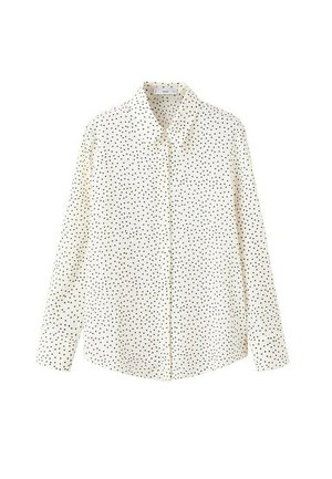 Chemise blanche à manches longues avec boutons, ornée de pois noirs, col classique et ourlet droit, présentée sur un fond blanc.