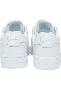 Vita lädersneakers med en slät yta, med en lågtoppad design, subtilt upphöjd logotyp och vadderad krage. Minimalistisk stil.