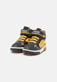 Baskets montantes avec un schéma de couleurs noir et jaune, tige en mesh et synthétique, sangle Velcro réglable et un graphique de dragon sur le côté.