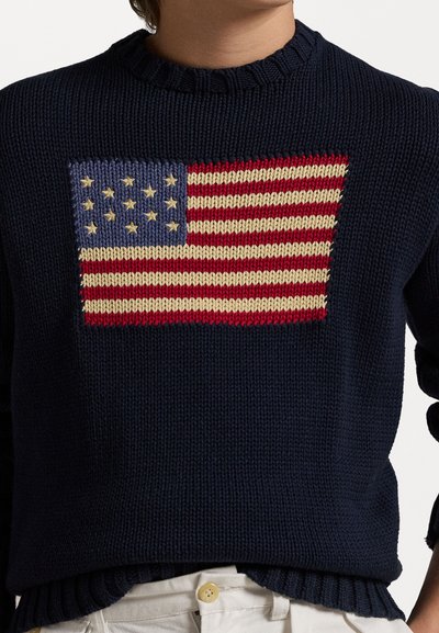 Mornarska pletena jopica z teksturiranim oblikom ameriške zastave v rdeči, beli in modri barvi, z rebrastim ovratnikom in robom.
