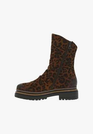 Bottines en suède marron avec un motif léopard, fermeture éclair sur le côté, semelle épaisse noire et détail de welting superposé.