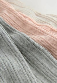 Miękki, dziany szalik w jasnym różu, szarości i kremie. Posiada strukturalny wzór z frędzlami na brzegach. Materiał jest ciepły i przytulny.