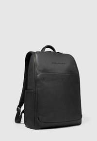 Sac à dos en cuir noir au design épuré, fermeture à glissière, logo sur le devant et bretelles rembourrées pour le confort.