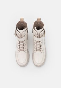 Když nosíte tyto slonovinové kožené kotníkové boty s vysokým střihem, předními tkaničkami a páskem přes střední část, oceníte také zip na boku pro snadné nazouvání.