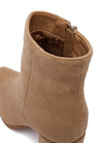 Hnedá semišová členková obuv s okrúhlou špičkou, textúrovaným povrchom a bočným zipsom. Vnútro obložené mäkkým materiálom pre väčšie pohodlie.