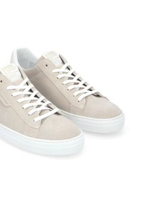 Beige Wildledersneaker mit weißen Schnürsenkeln und Gummisohlen. Verfügt über ein strukturiertes Obermaterial und ein minimalistisches Design mit dezentem Branding.