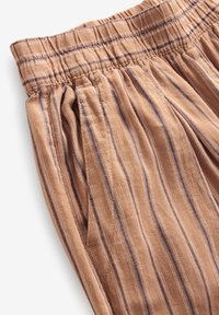 Pantaloni a righe marroni con vita elastica, caratterizzati da linee verticali di colore azzurro chiaro e bianco, realizzati in un tessuto morbido e texture.