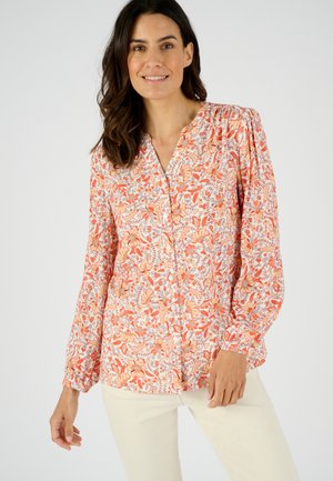 Blusa floreale con scollatura a V, maniche lunghe, tessuto morbido con motivi arancioni, rosa e blu, e chiusura con bottone frontale.