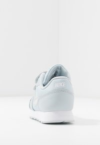 Sneaker Nike azzurro chiaro con tomaia in pelle testurizzata, suola bianca e dettagli del logo sul tallone. Design semplice dei lacci.