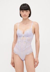Prosojna bodysuit v lilaste barvi, okrašena z encami, z V-izrezom, nastavljivimi naramnicami in cvetličnimi vezeninami po telesu in bokih.