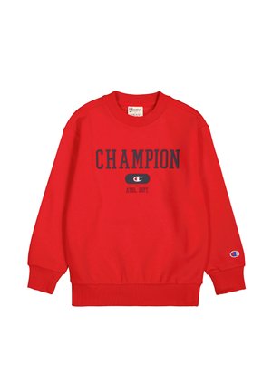 Sweat-shirt rouge avec "CHAMPION ATHL. DEPT." en bleu marine, poignets et ourlet côtelés, avec un patch logo sur la manche. Matière en coton doux.