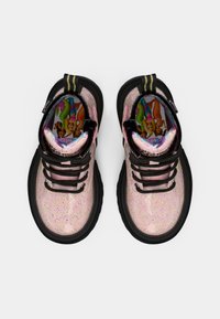 Zapatillas de deporte con brillo rosa, suela y cordones de goma negra; presentan un forro colorido con personajes de dibujos animados y una pestaña de tira a rayas.