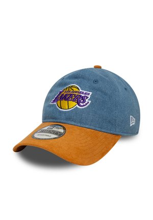 Casquette en denim avec une visière en cuir suédé marron, ornée d'un logo brodé en violet et jaune des Los Angeles Lakers à l'avant.