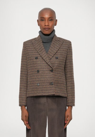Giacca doppiopetto a motivo houndstooth marrone e crema con due bottoni neri, abbinata a un dolcevita scuro. Design di vestibilità regolare.