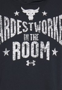 Felpa nera in cotone, con scritte bianche in stile usurato, stelle e grafica di un toro. Riporta la scritta "HARDEST WORKER IN THE ROOM".