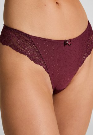 Bordeaux kanten slip met stippenstructuur, met een strikdetail aan de voorkant en geschulpte randen voor extra ontwerpintrige.