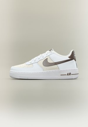 Niskie białe i beżowe buty sportowe z brązowym logo Nike i napisem "AIR" na podeszwie, na neutralnym tle.