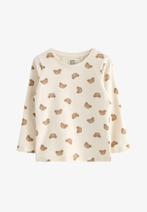 Langærmet top lavet af blødt, cremefarvet stof med et gentaget bjørneansigt mønster i brunt. Rund halsudskæring og afslappet pasform.