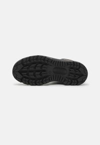 Talpa de pantof din cauciuc negru cu un model de profil rugged pentru aderență. Include detalii de marcă, toc plat și o suprafață texturată pentru prindere.