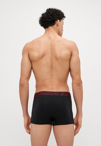 Schwarze Boxer-Shorts mit einem roten "ARMOR"-Bund. Bieten eine enge Passform und glattes Material, mit einer niedrigen Taille und flachen Nähten.