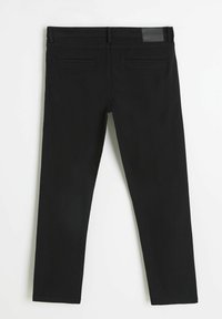 Czarne legginsy o slim fit, z gładką fakturą, średnim stanem, pętelkami na pasek oraz dwoma tylnymi kieszeniami. Skórzana naszywka w okolicy pasa.