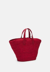 Czerwona, pleciona torba tote z szerokim, otwartym wierzchem i dwoma czerwonymi skórzanymi uchwytami. Teksturowana powierzchnia z pojemnym, zwężającym się kształtem.