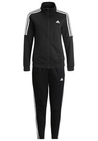 Survêtement Adidas noir avec détail à trois bandes blanches sur les manches et le pantalon, veste zippée intégrale, poignets élastiques, et logos Adidas sur la poitrine et la cuisse.