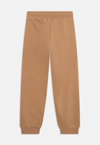 Browni kokvilnas sporta bikses ar elastīgu jostu un piedurknēm, ar gludu tekstūru un brīvu piegriezumu.