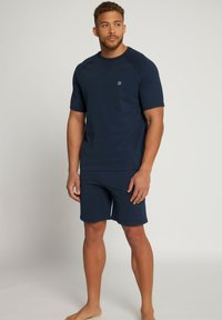 Conjunto de loungewear a juego en azul marino que incluye una camiseta de cuello redondo y manga corta, y pantalones cortos hasta la rodilla, fabricado en un tejido suave y texturizado.