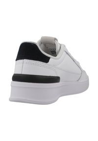Sneaker bianco con tomaia in pelle liscia, linguetta sul tallone in suede nero e suola in gomma nera a contrasto. Presenta dettagli cuciti sui lati.