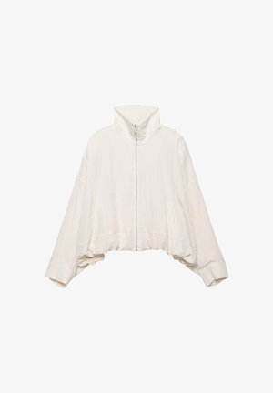 Jachetă albă cu mâneci lungi și fermoar, guler înalt și tiv elastic, concepută cu un croi larg și manșete late.