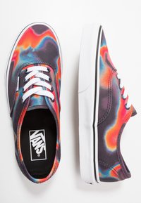 Sneakers in tela con un motivo di fiamme multicolore in tonalità di rosso, arancione, blu e nero, con lacci bianchi e dettagli bianchi sulla suola.