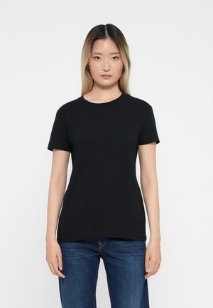 Zwarte t-shirt met korte mouwen van zachte katoen, met een ronde halslijn en een relaxte pasvorm. Gecombineerd met blauwe spijkerbroeken.