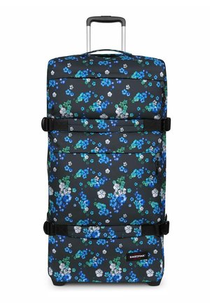 Valise souple à roulettes avec motif floral bleu, blanc et vert, poignée extensible, deux sangles de compression noires et poches zippées.