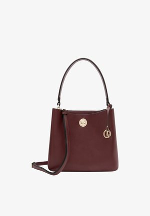 Sac à main en cuir bordeaux avec une forme structurée, doté d'un médaillon en or et d'un charme amovible, texture lisse et double poignées.