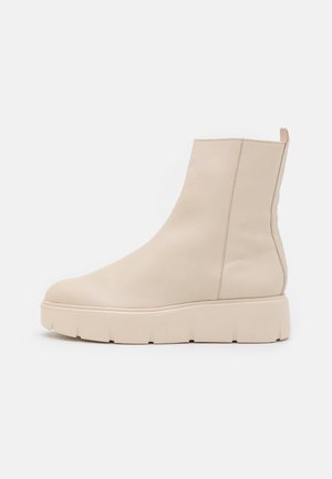 Beige ankle boots made of smooth leather with a chunky sole, featuring a minimalist design and side seam stitching.