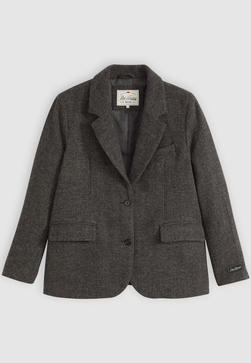 Grå tweedblazer med snedknäppning, två framfickor och två knappar. Har en mjuk foder och sidetikett med varumärkeslogotyp.