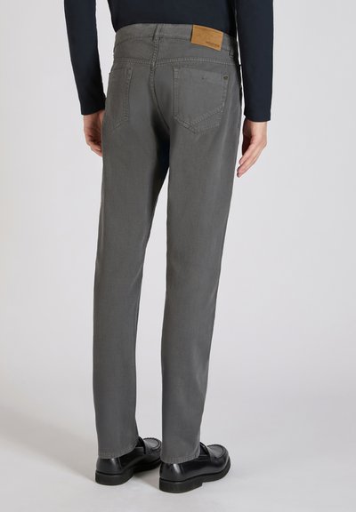 Chinos de algodón grises con un corte recto, que cuentan con un acabado texturizado, bolsillos traseros visibles y un parche de cuero marrón en la cinturilla.