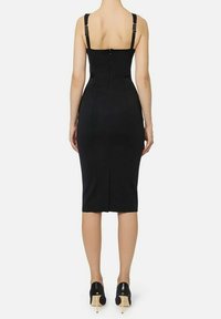 Vestito nero aderente con spalline larghe, lunghezza media e zip centrale posteriore. Presenta uno spacco sull'orlo e una texture del tessuto liscia.