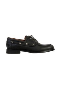 Chaussure bateau en cuir noir avec laçage sur le devant, couture moc toe, et œillets métalliques, vue de profil sur fond blanc.