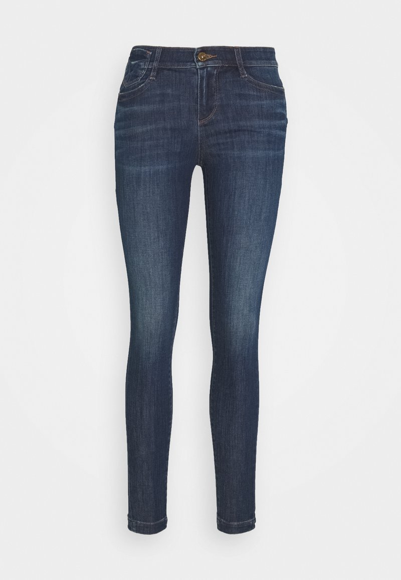 Skinny jeans in donkerblauwe denim. Kenmerken zijn een standaard knoopsluiting, zijzakken en een soepele textuur. Heeft een aansluitende silhoeët.
