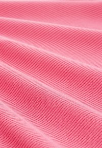 Rosa geriffelter Stoff mit einer strukturierten Oberfläche und subtilen Wellen in der Webung, der ein glattes und flexibles Material präsentiert.