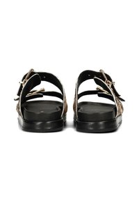 Sandali neri con cinturini intrecciati beige, dotati di due fibbie regolabili. La suola è liscia e piatta, offrendo un design minimalista.