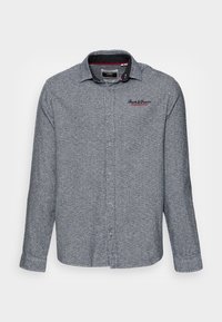 Šedá košile na knoflíky s dlouhým rukávem, jemnou texturou, kontrastním límcem a vyšitým logem na hrudi. Klasický střih.