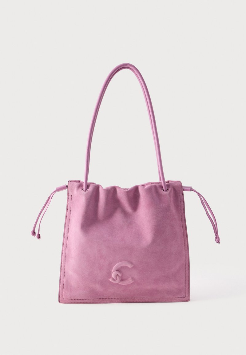Μαλακή ροζ σουέτ τσάντα ώμου με μακριές λαβές, πλευρές με κορδόνι και ανάγλυφο διακοσμητικό λογότυπο στο κέντρο μπροστά.