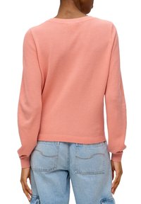 Pull-over en tricot rose doux texturé. Comprend un col rond et des poignets côtelés, avec une coupe décontractée et sans éléments métalliques visibles.