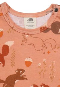 Bio-Baumwollshirt mit einem rosa Hintergrund, verziert mit einem verspielten Muster aus Eichhörnchen und Füchsen, akzentuiert durch Eicheln und Grünpflanzen. Druckknopfverschluss am Kragen.