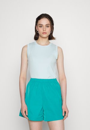 Top sem mangas azul claro combinado com calções de cintura elástica turquesa. O tecido parece suave e leve, com um ajuste descontraído.