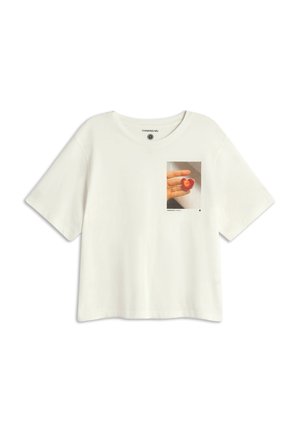 T-shirt blanche à manches courtes en coton avec un imprimé sur la poitrine d'une main tenant un fruit en forme de cœur sur un fond clair.